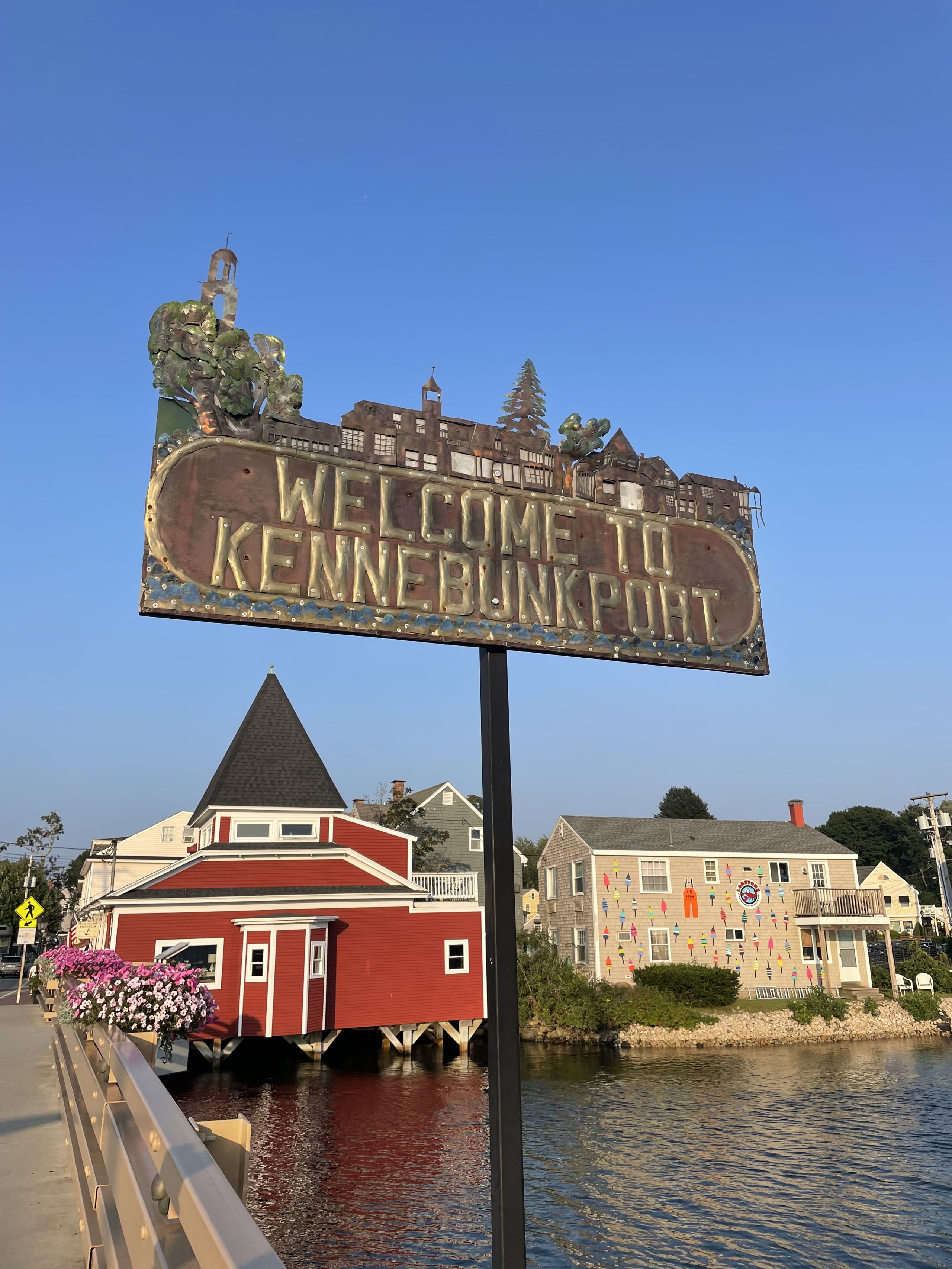 A town featuring a red dockhouse and a sign reading "Welcome to Kennebunkport".