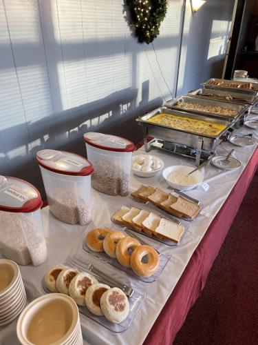 Breakfast buffet featuring cereals, an assortment of breads, boiled eggs, yogurt, and chafing trays with hot breakfast foods.